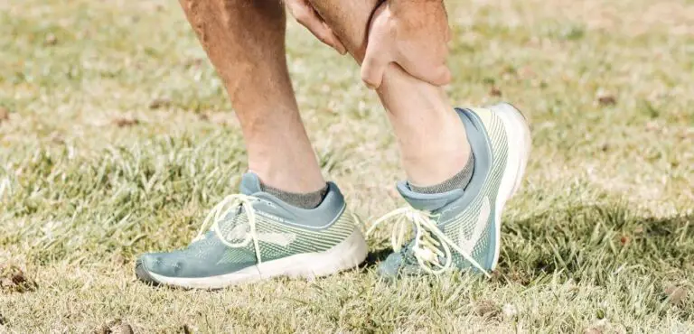 runner grabbing ankle - ankle support kt tape