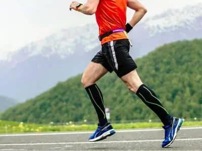 Athlete is wearing compression socks while running. 9 Ways Compression Garments Help You Lose Weight