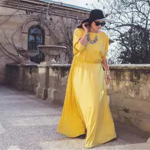 model wearing a plus size prom dress that is yellow and flowing. Plus size prom dresses are available in a way range of patterns, and styles.