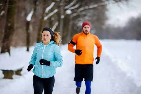 What to wear for running in the cold? athletes wearing wind-resistant running jackets and compression tights