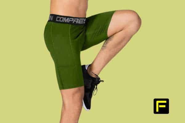 Athlete wearing green compression running shorts