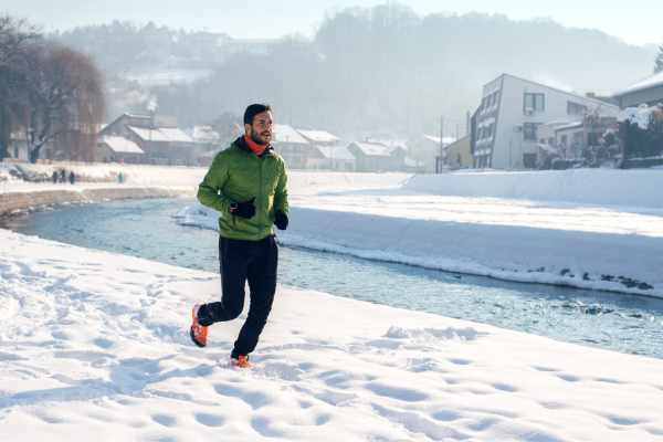 running in cold temperatures. man running in the snow