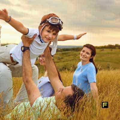 Energetic father lifting his child in a field while family smiles, symbolizing strength, vitality, and the benefits of creatine for age-related muscle loss and preventing sarcopenia.