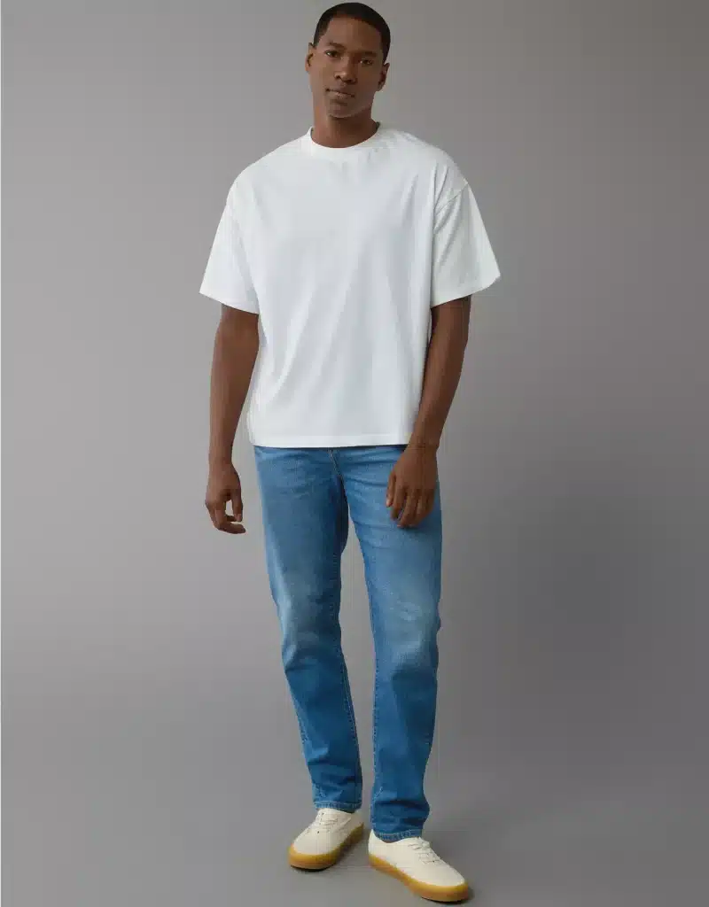 11 Best Jeans for Men with Big Butts: Finding Your Perfect Fit 4 Model wearing American Eagle AirFlex+ Athletic Fit with loose fitting white t-shirt.