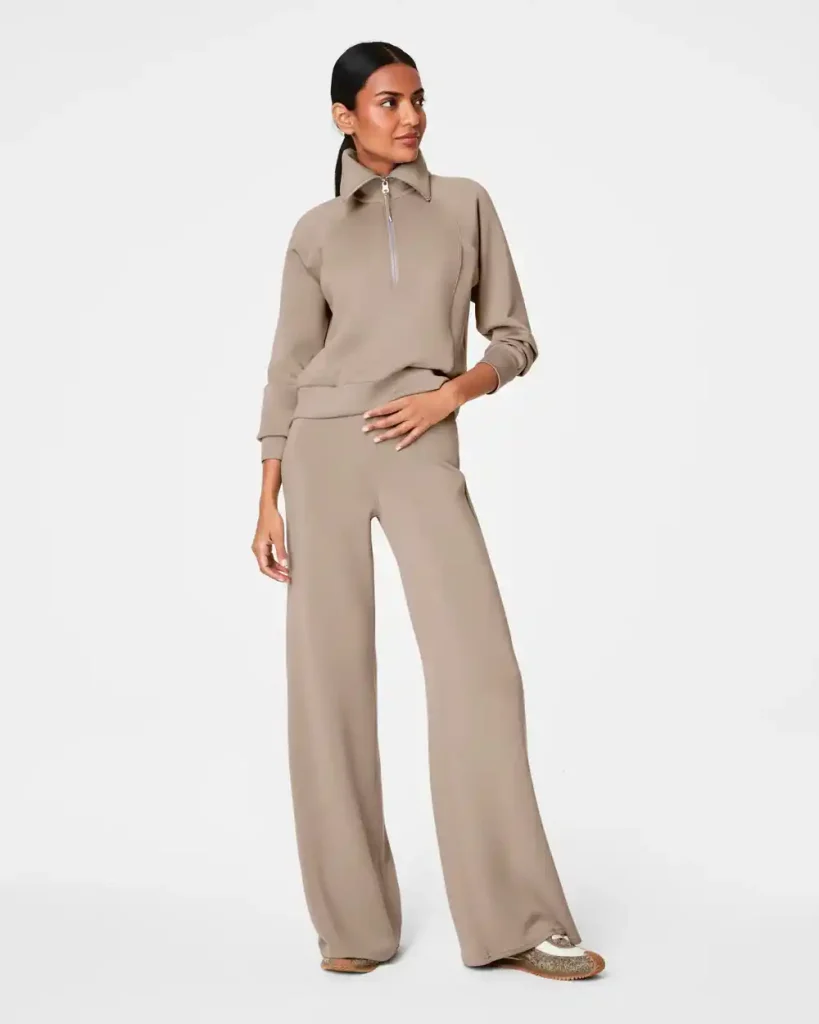 Best Wide Leg Pants for Women Over 50: Stylish, Comfortable, Flattering Options for 2025 8 Woman wearing a taupe matching set featuring a quarter-zip pullover and wide leg Spanx pants, standing in a relaxed pose against a plain white background.