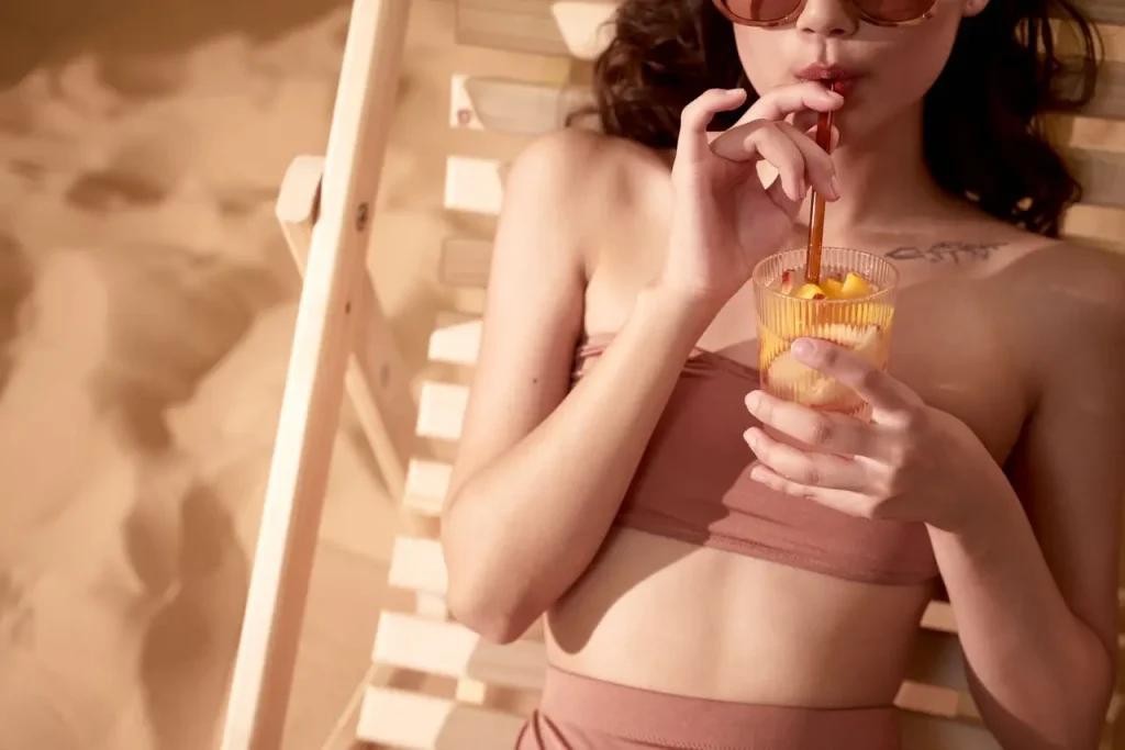 Best Australian Sunscreens for Body and Face: Why Down Under Does SPF Better 7 Woman relaxing on a beach chair in direct sunlight wearing sunglasses and a bikini, illustrating why water-resistant Australian body sunscreen SPF 50 is essential for extended outdoor sun exposure