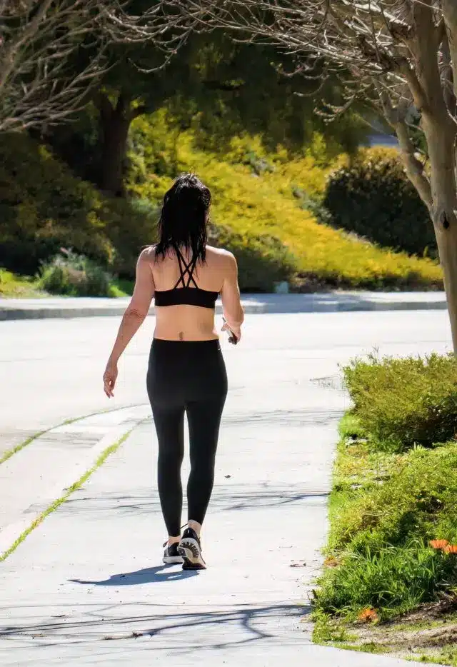 The Walking Plan That Melts Fat After 50 (No Gym Required) 7 Woman over 50 taking a post-meal walk after dinner to help control blood sugar